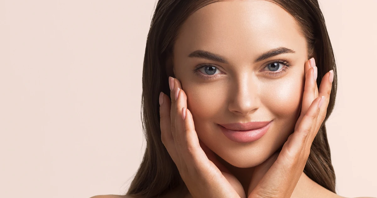 Woman with glowing, smooth skin gently touching her face, showcasing results from the ZO® 3-Step Peel in Reno, NV.